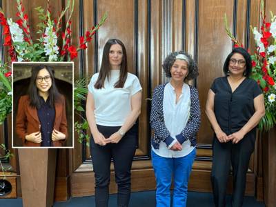 Drei Frauen stehen im Hodlersaal der Neuen Rathauses zwischen zwei großen Blumensträußen. Links ist das Bild einer weiteren Frau nachträglich eingefügt worden